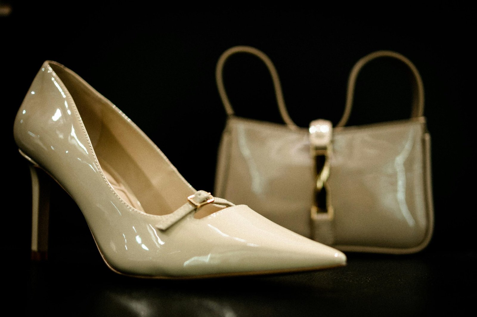 Stylish beige high heel shoe with matching handbag in elegant fashion display.